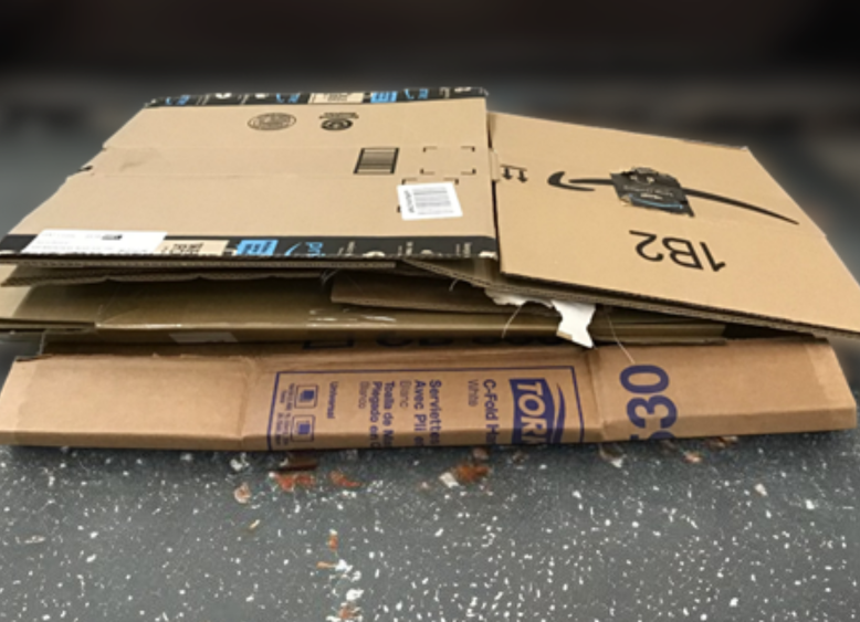 Flattened cardboard boxes on a gritty garage floor.
