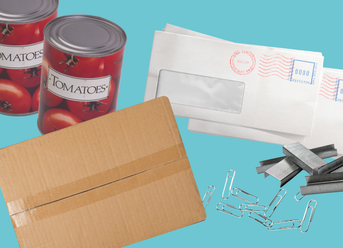 A labeled vegetable can, a window mailer, a taped up cardboard box, a pile of paperclips and staples
