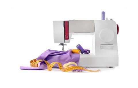 A sewing machine with fabric, thread and tape measure